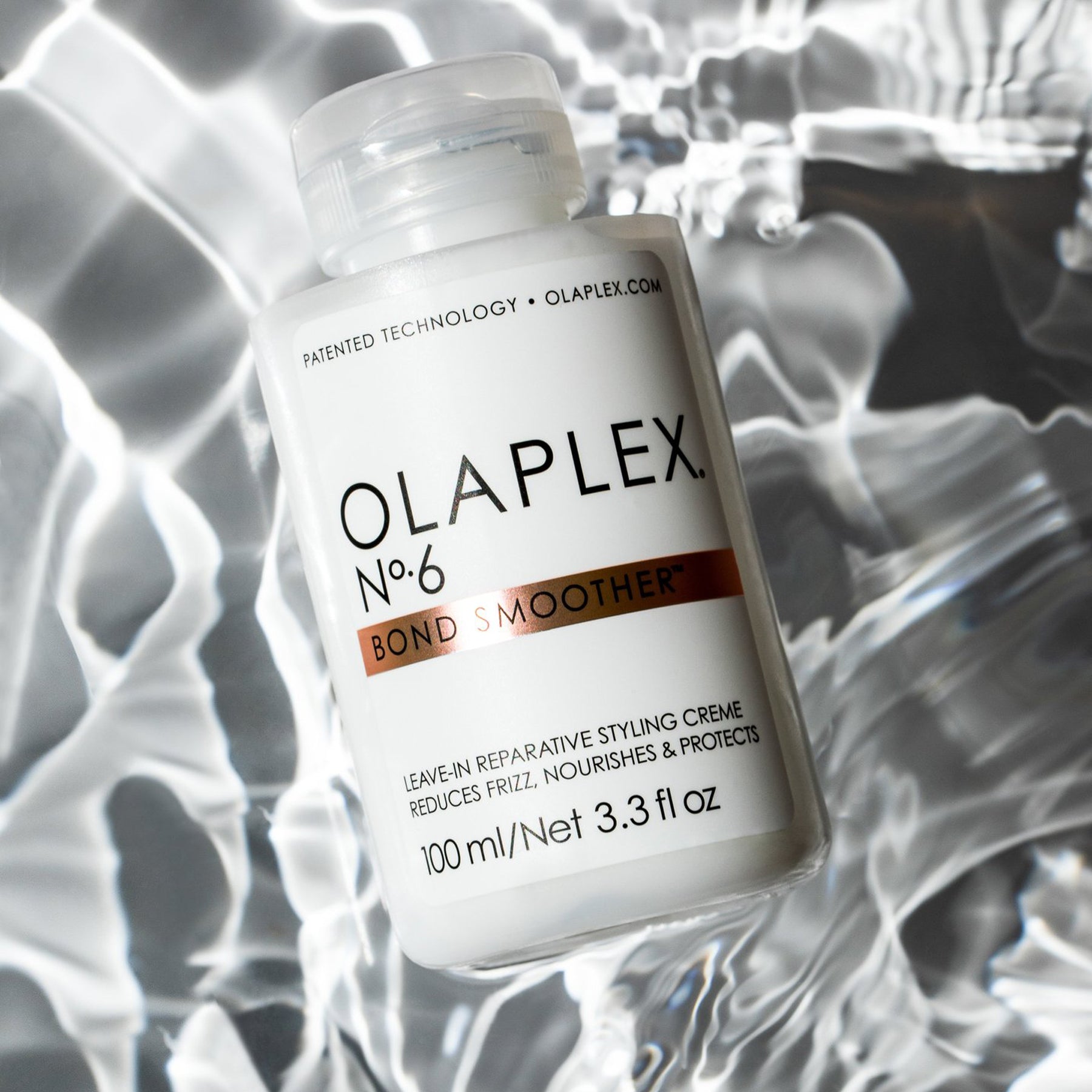 A floating Olaplex No. 6 Bond Smoother in water, 3.3 Fluid Ounces / 100 Milliliters.
